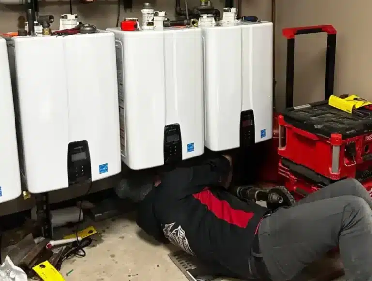 JT Plumbing Heating & Air tech installing tankless water heaters in Fort Collins.